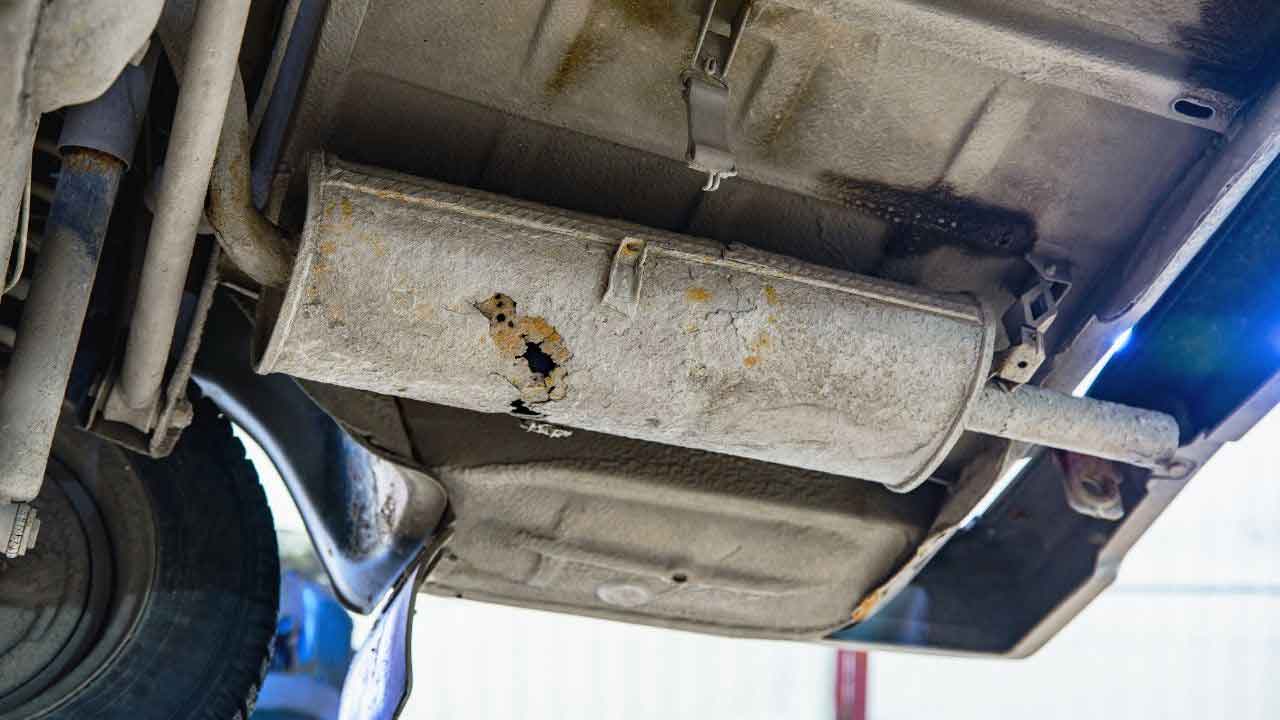 a rusted muffler with a leak installed in the vehicle